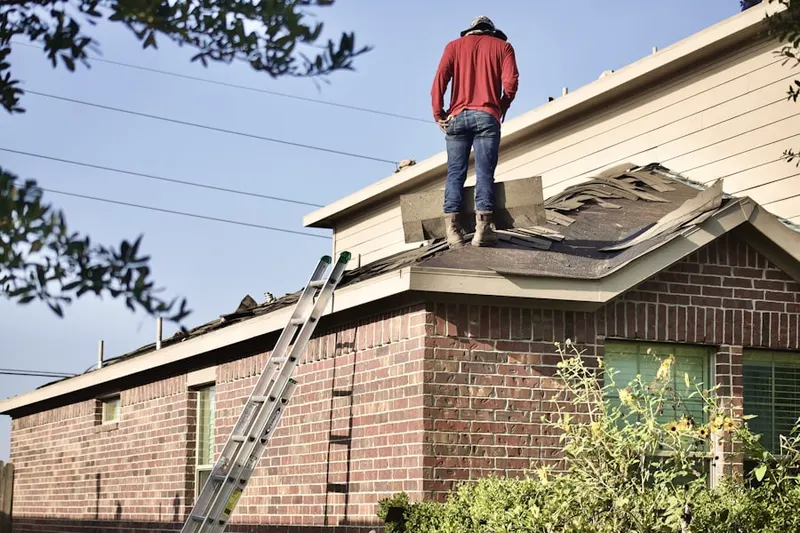 Professional roofer working on a residential roof in Meadow Oaks Haltom